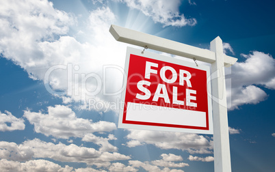 For Sale Real Estate Sign over Clouds and Blue Sky