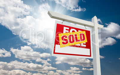 Sold For Sale Real Estate Sign over Clouds and Blue Sky