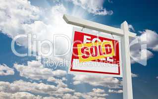 Sold For Sale Real Estate Sign over Clouds and Blue Sky