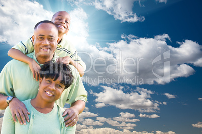 Happy African American Family Over Blue Sky and Clouds