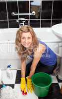 Smiling woman cleaning a bathroom