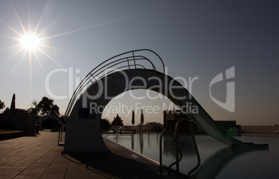 bath pool with white slide during a sunset