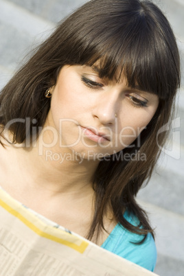 Young woman reading a newspaper