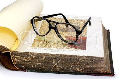 An open old book and spectacles