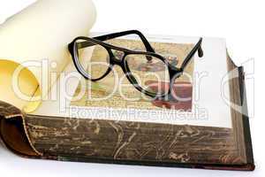 An open old book and spectacles