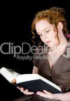 Beautiful girl with red hair reading a book