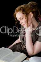 Beautiful girl with red hair reading a book