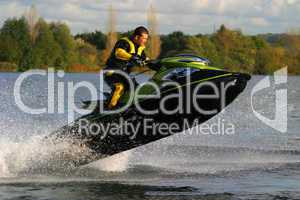 Man Riding Jet Ski at Speed and Jumping out of the Water