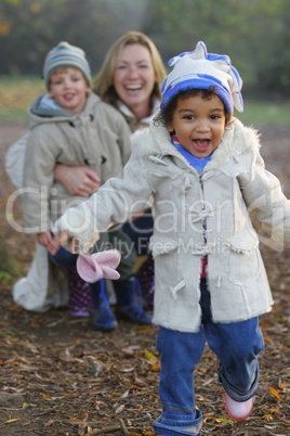 A beautiful mixed race girl runs towards the camera laughing whi