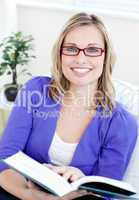 Portrait of an attractive woman with glasses reading a book