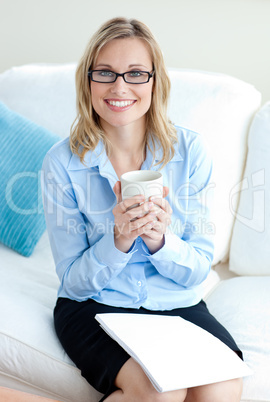 Charismatic businesswoman holding cup wearing glasses