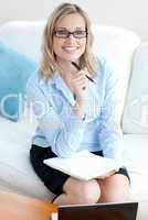 Confident businesswoman holding a pen wearing glasses
