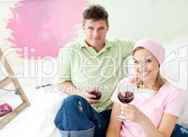 Delighted couple having free time together with a glass of wine