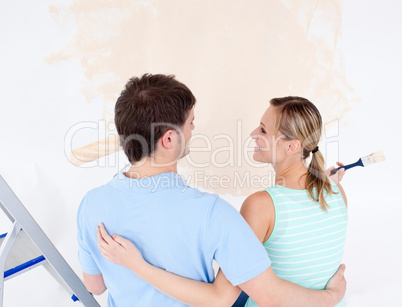 Affectionate couple painting a room