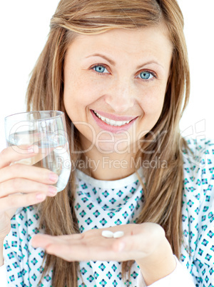 Sick young woman holding a glass of water and pills