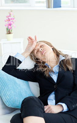 Stressed businesswoman slepping on a sofa