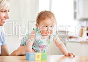 Smiling woman playing with her girl in the living-room