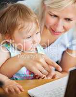 happy woman surfing on the internet with her girl in the living-