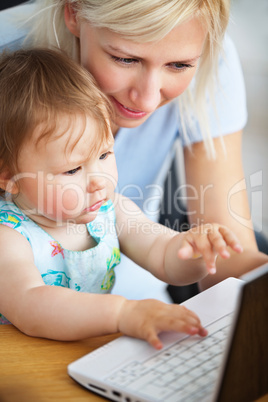 Smiling family having fun with a laptop in the living-room