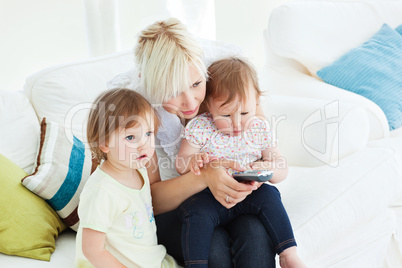 happy woman using a remote with her girl in the living-room