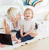 Smiling family having fun with a laptop in the living-room