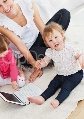 Beautiful family having fun with a laptop in the living-room