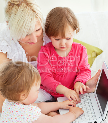 Cheerful family having fun with a laptop in the living-room