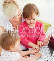 Cheerful family having fun with a laptop in the living-room
