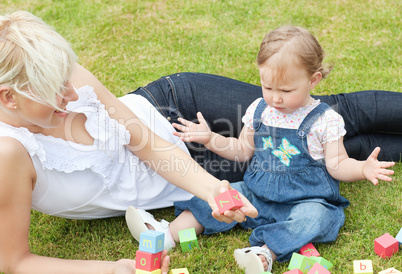 Cheerful Mother and daughter lying on the grass together