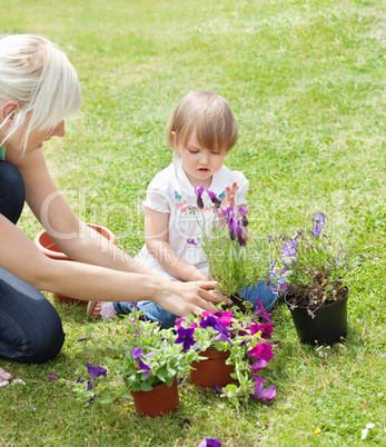 Smiling Mother showing her daughter a purple flower