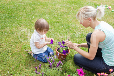 Blond Mother showing her daughter a purple flower