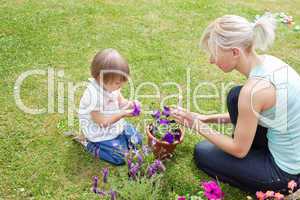 Blond Mother showing her daughter a purple flower