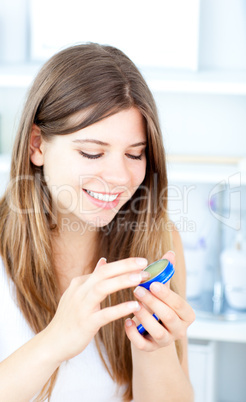 Radiant woman using  cosmetic cream