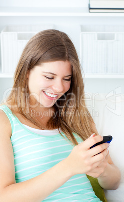 Laughing young woman writing a text message