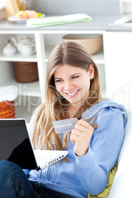 Happy woman with a credit card and a laptop