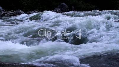Rushing river water cascades over rocks