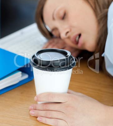 Languorous woman sleeping on table in office