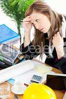 Stressed businesswoman sitting in her office in front of the tab