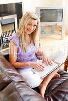 Cute woman sitting on sofa and working