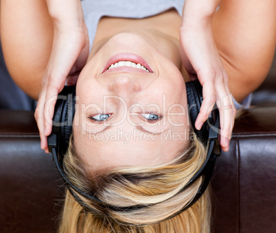 Glowing woman lies on a sofa and listen music