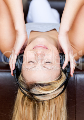 Sleeping woman lies on a sofa and listen music