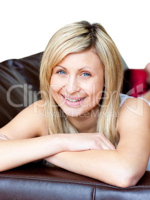 Young woman lies on a brown sofa