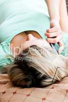Positive woman lies on sofa and phoning