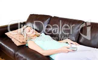 Laid-back woman lies on sofa and watches TV