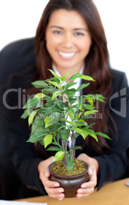 Pretty woman holding a plant in her hands