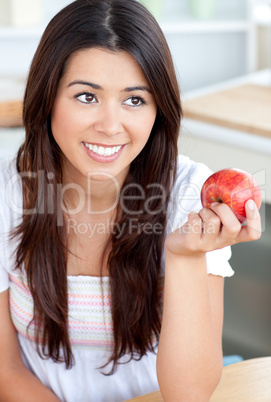 Attractive woman eating an apple in kitchen