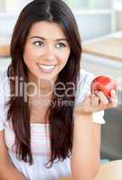 Attractive woman eating an apple in kitchen