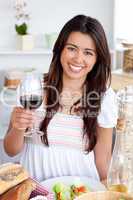 Good-looking woman sitting on sofa and drinking
