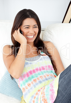 Radiant woman sitting on sofa and phoning