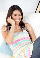 Radiant woman sitting on sofa and phoning